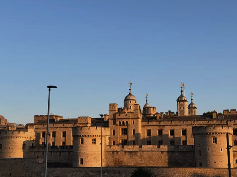 The Tower of London and its curtain walls above the Thames at sunset
